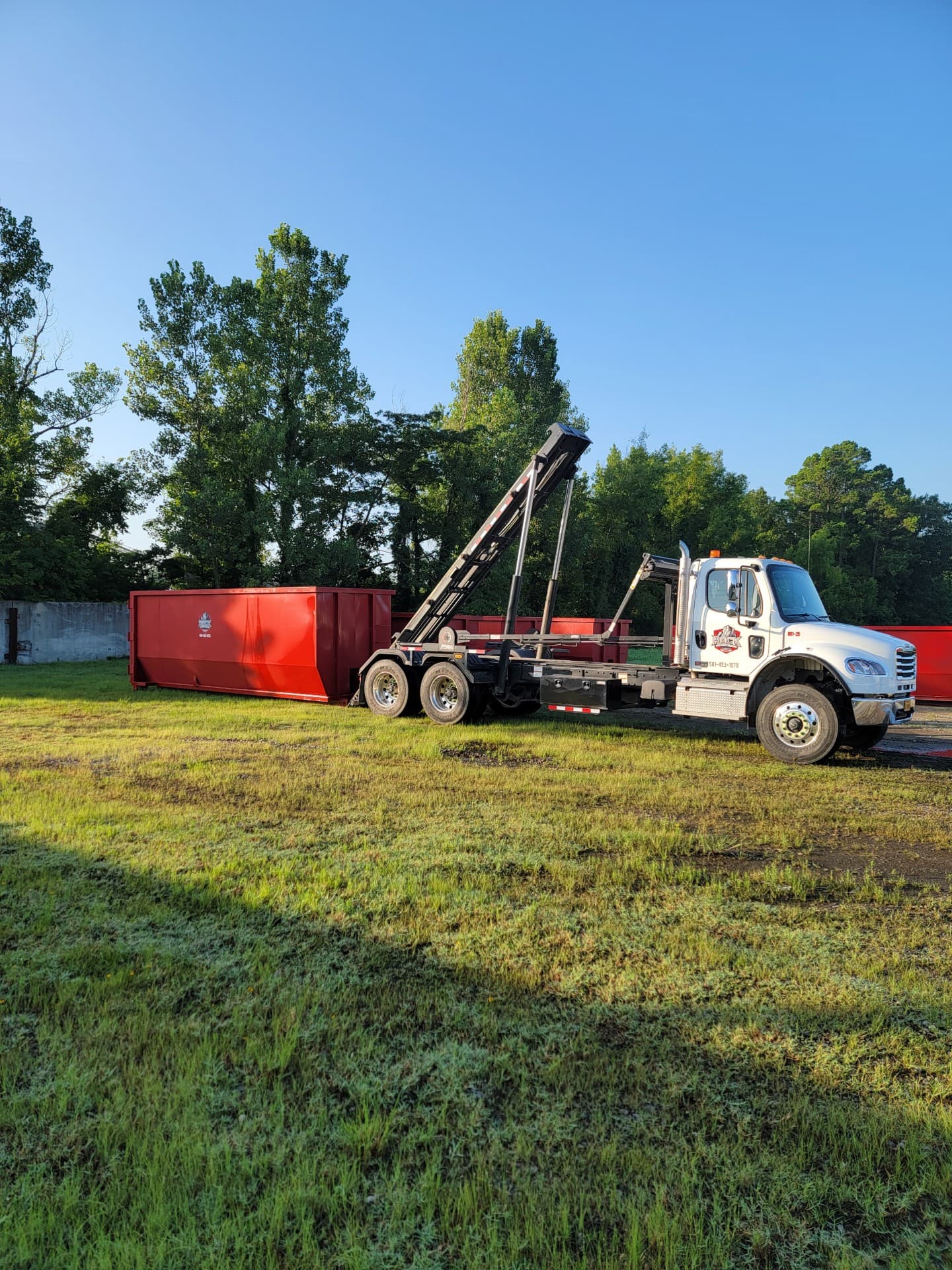 Red dumpster along a residential driveway